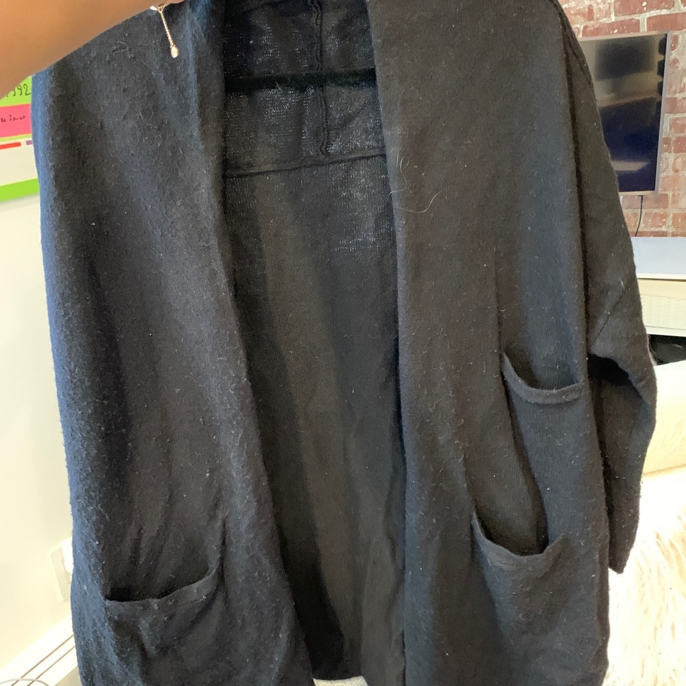 Black Sandro wool sweater with pockets and tuxedo detailing. Comes past hip
